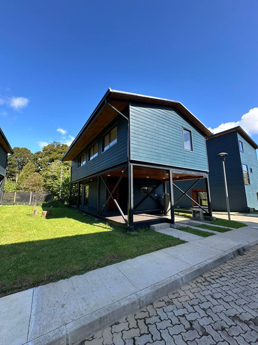 Casa sobre pilares con cielo de madera y terraza cubierta